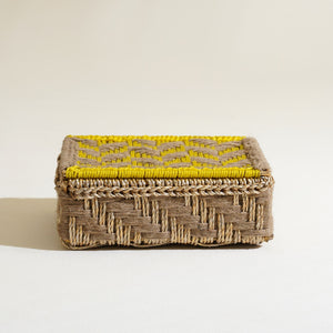 Woven rectangular basket with yellow interior on a beige background